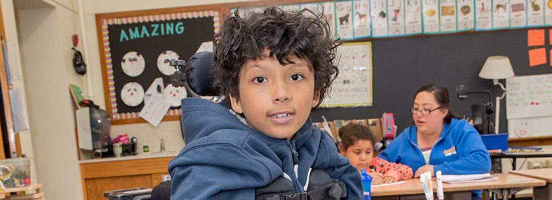 Student smiling in class looking at the camera