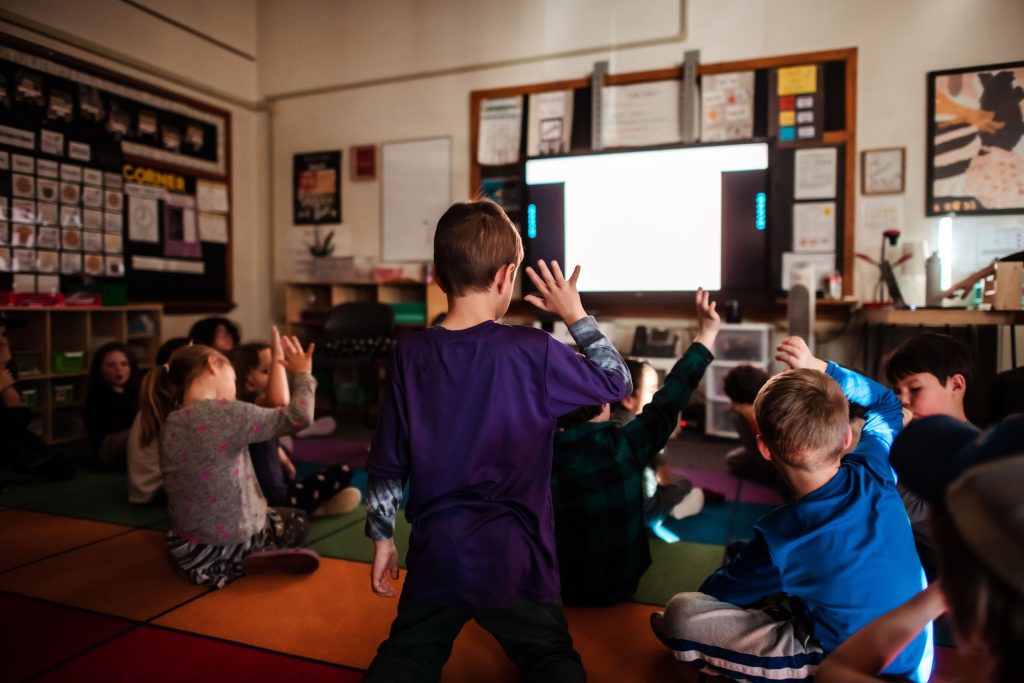 kids on carpet looking at screen